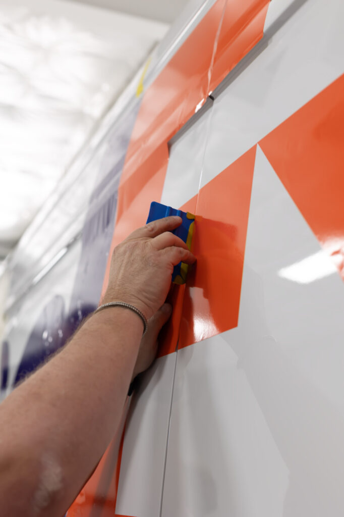 Installation of re branded commercial fleet vehicle graphics on FedEx van by Classic Pinstriping in Dallas Texas
