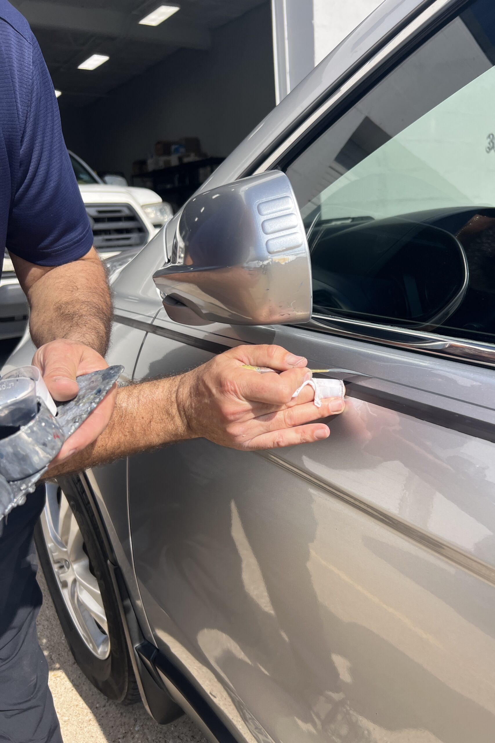 Action shot of hand painted pinstripe as it is painted on a silver car by Master pinstriper from Classic Pinstriping in Dallas Texas