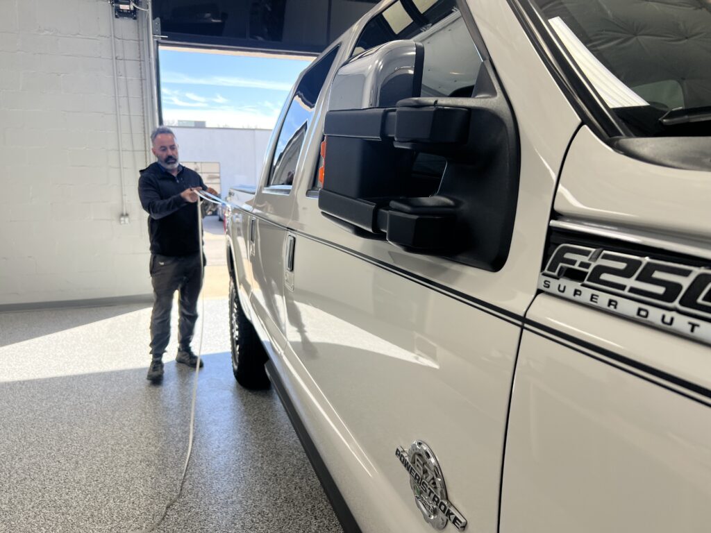 Installation of two tone vinyl pinstripes by Classic Pinstriping in Far North Dallas Texas on white ford f-250 truck